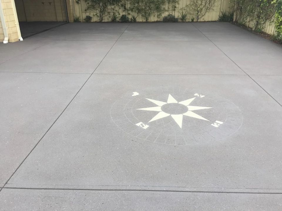 Grey spray-on driveway with a compass stencil in the centre