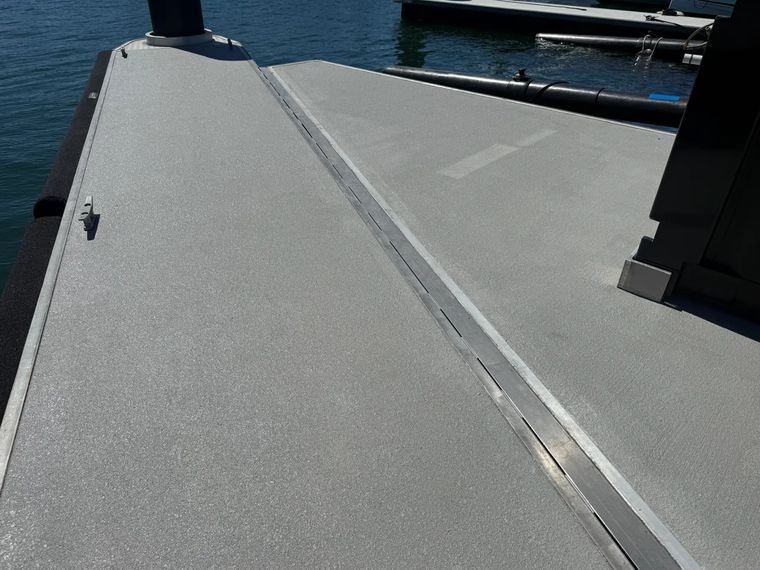 Grey plain spray-on concrete deck beside a marina
